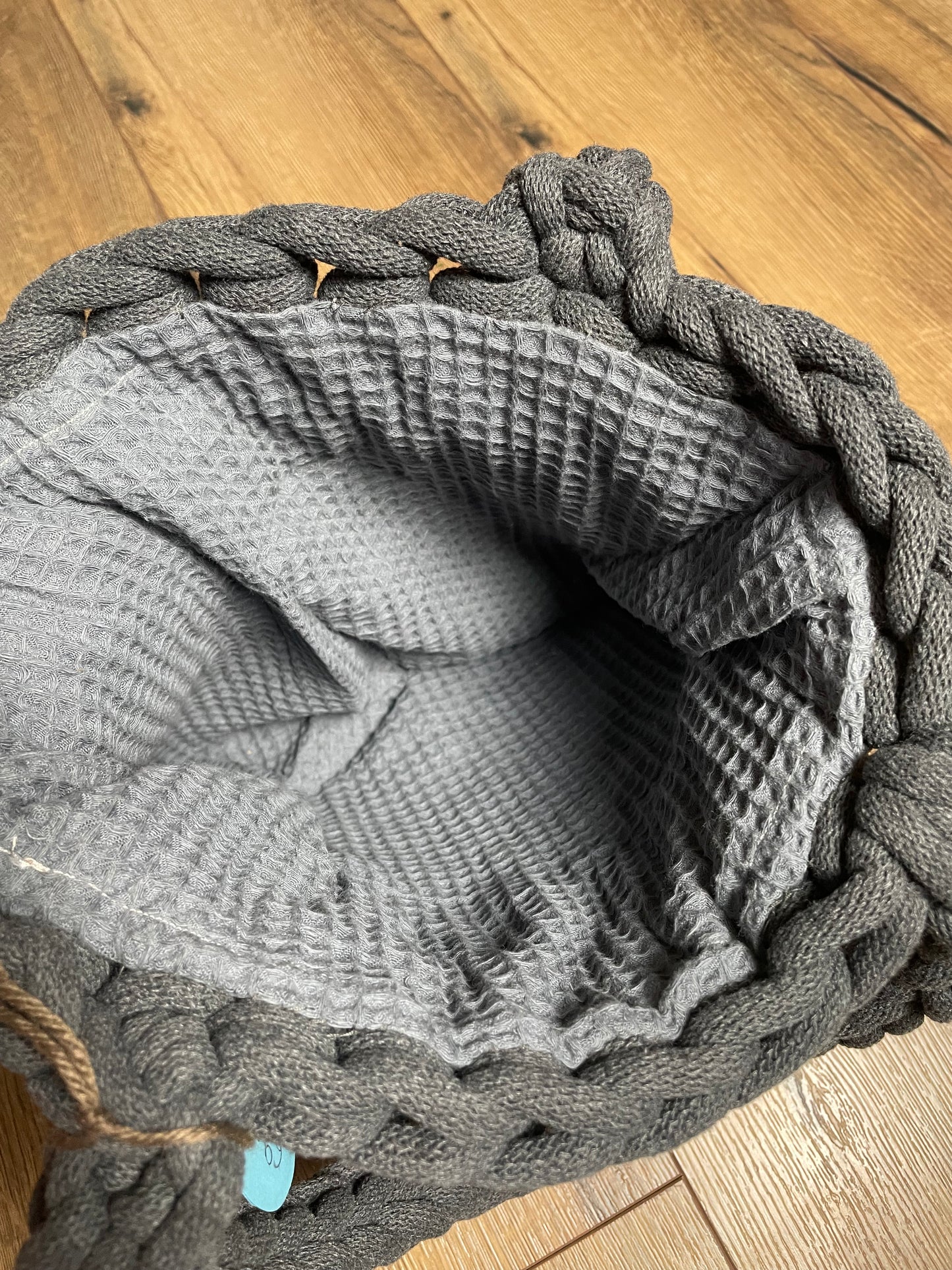 Blick von oben in eine der gehäkelten BEATE Taschen in grau. Das Innenfutter ist hier ein Waffelstoff in etwas hellerem Grau als das Garn der Tasche.