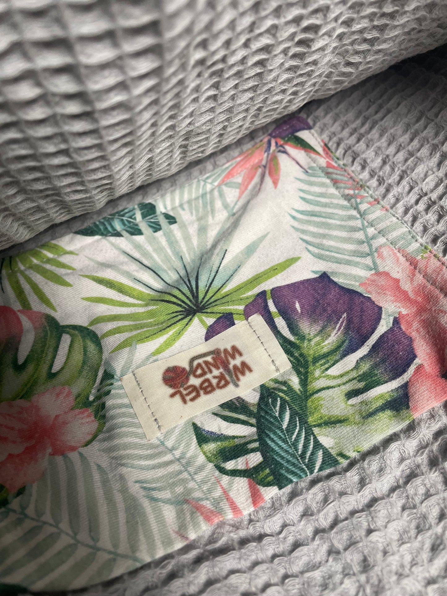 FLORA Häkeltasche in Mauve Rosa, Innenansicht: geöffnete Tasche zeigt das hellgraue Innenfutter aus Baumwoll-Waffelpiquet-Stoff mit kleiner aufgenähter Innentasche mit floralem Muster in grün, lila, blau-grau und rosa.
