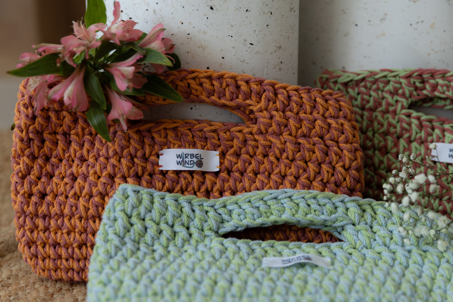 Nahaufnahme des ersten Bildes. Die Tasche oben links mit der Blume füllt fast ganzes Bild aus. Die anderen beiden Taschensind abgeschnitten und unscharf.