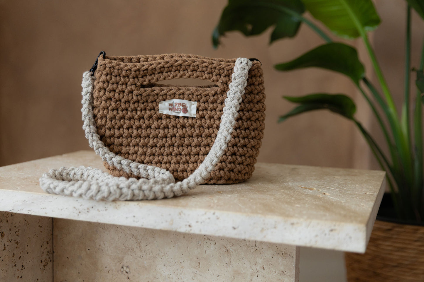 Nahaufnahme des ersten Bildes, die Tasche füllt nun fast das ganze Bild aus, der Hintergrund ist verschwommen. Die gehäkelten Maschen der Tasche sind sehr deutlich zu sehen.