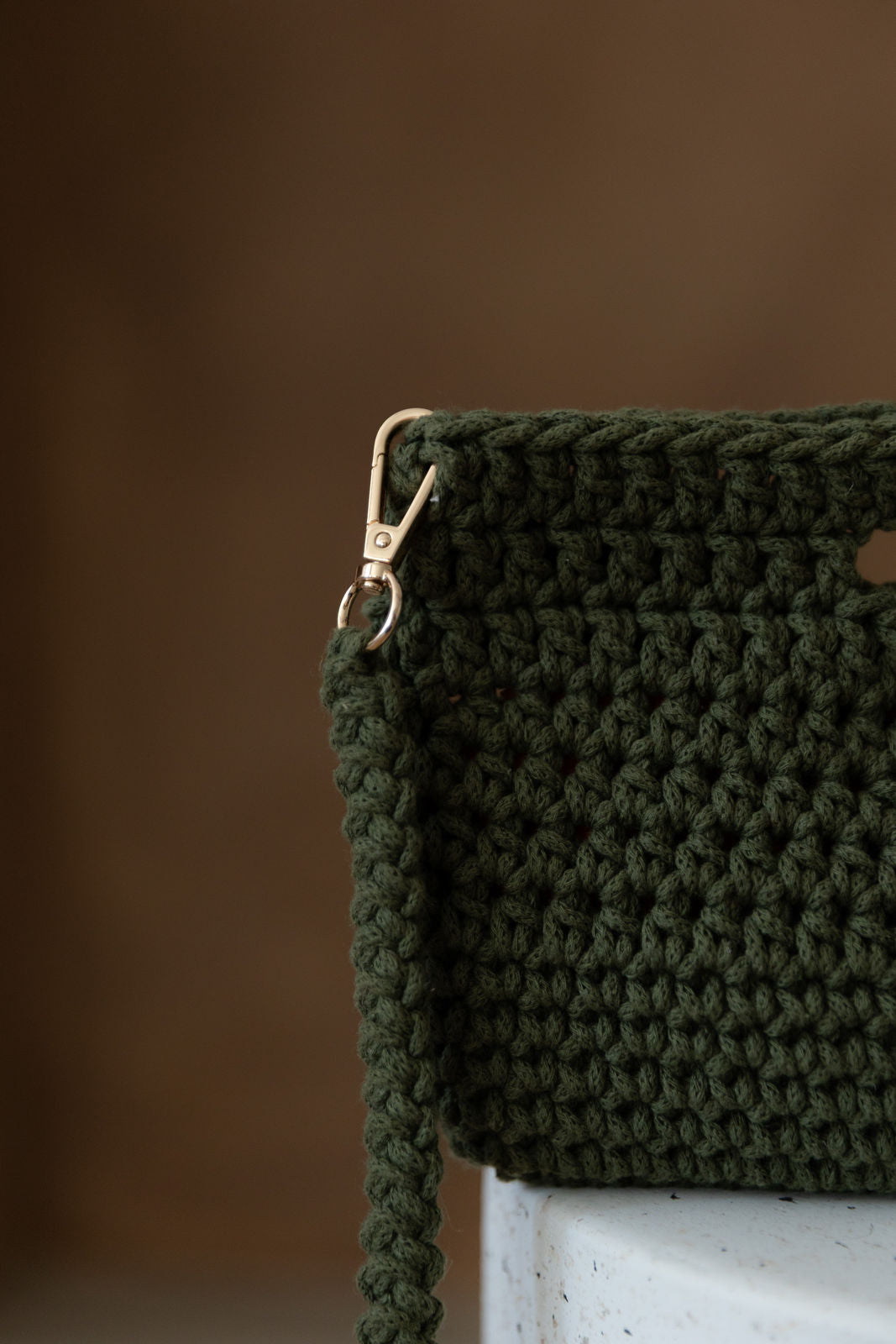 Nahaufnahme grüne Tasche. Hintergrund unscharf. Tasche ragt rechts aus Bild heraus.
