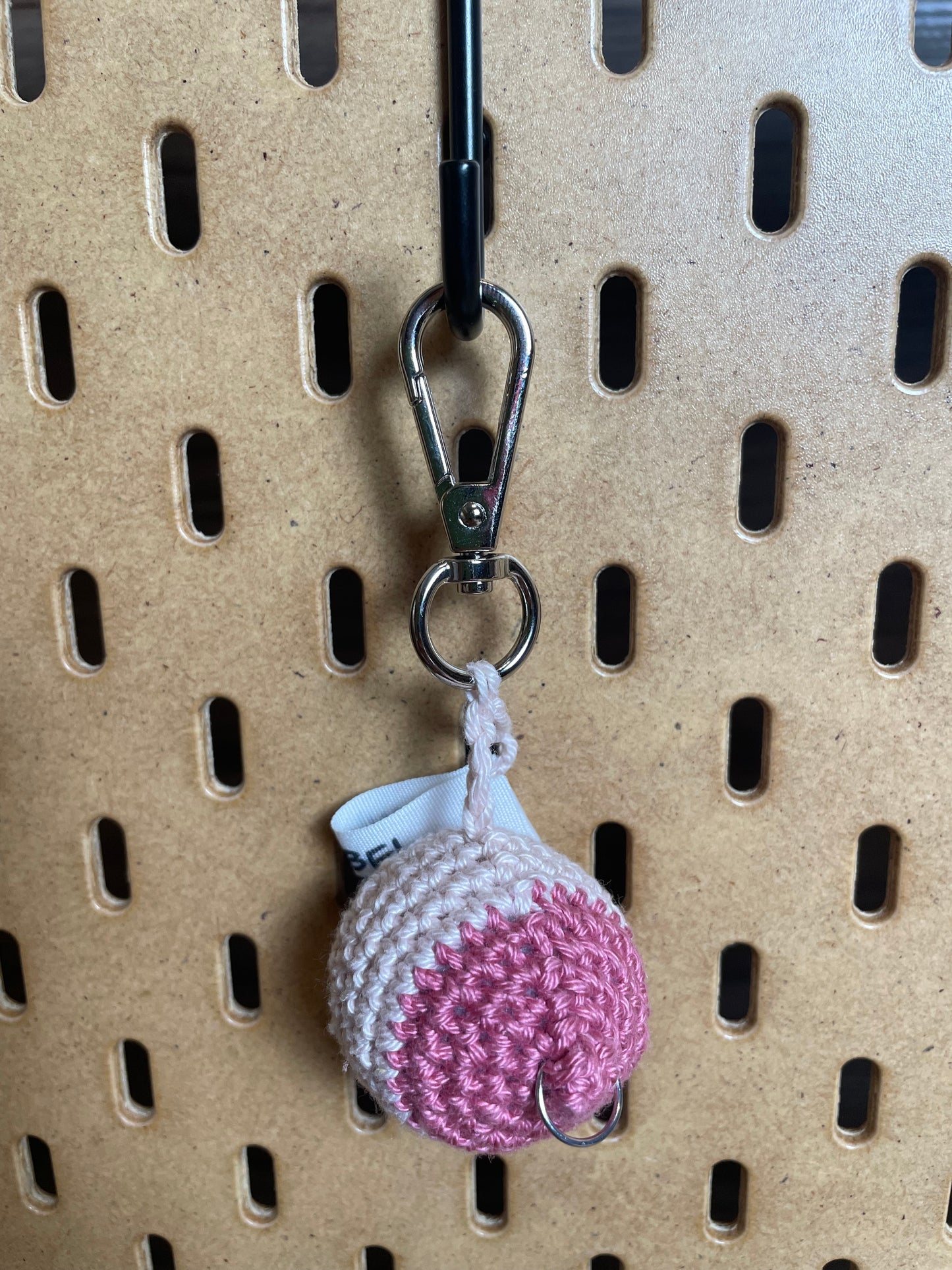 Nahaufnahme eines Brustanhängers mit silbernem Karabiner: großer Vorhof mit einem silbernen Piercing.