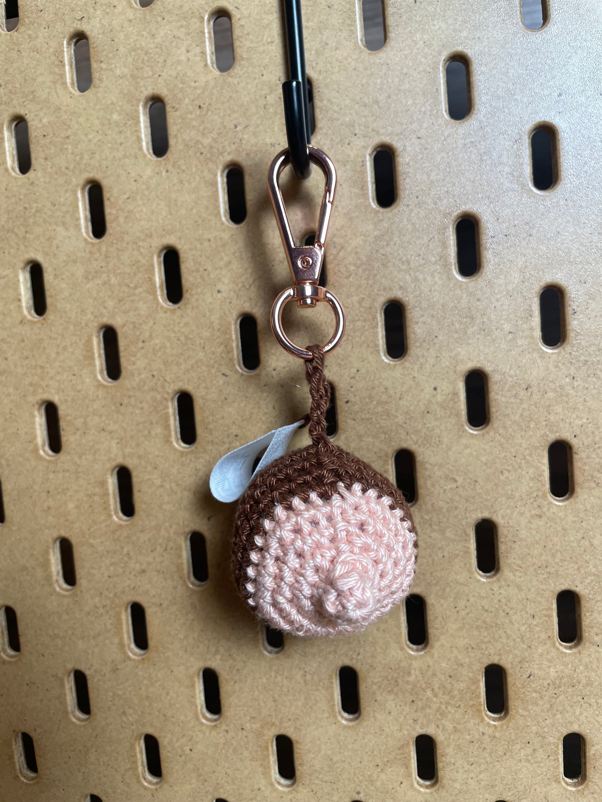 Nahaufnahme eines Brustanhängers mit roséfarbenem Karabiner und großem Vorhof.