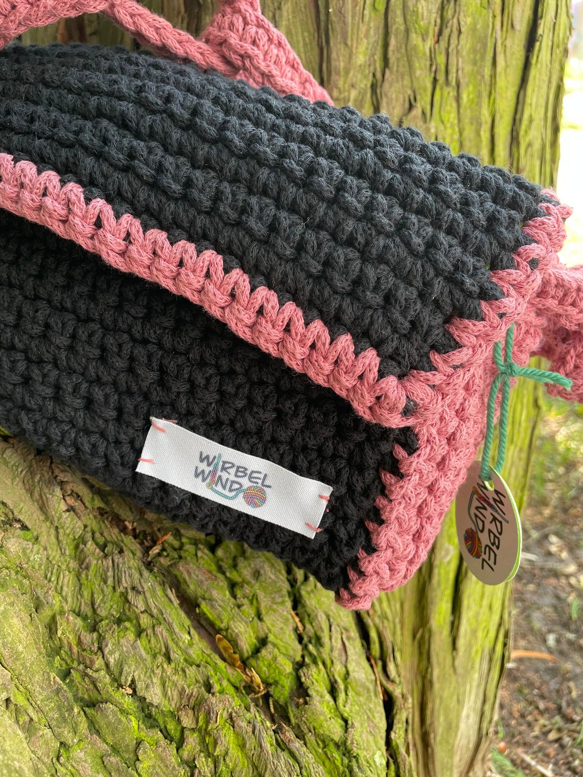 Nahaufnahme des Logos rechts unten, welches mit pinkem Garn festgenäht wurde.