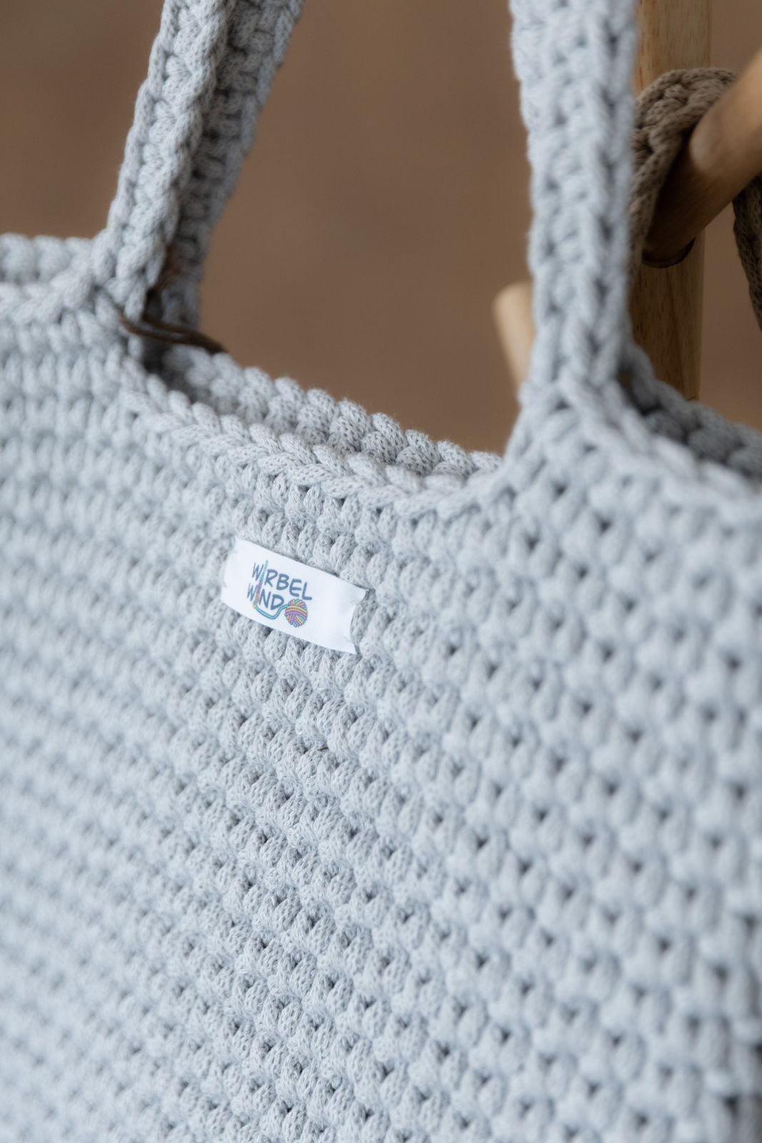 Nahaufnahme der gehäkelten grauen Schultertasche.