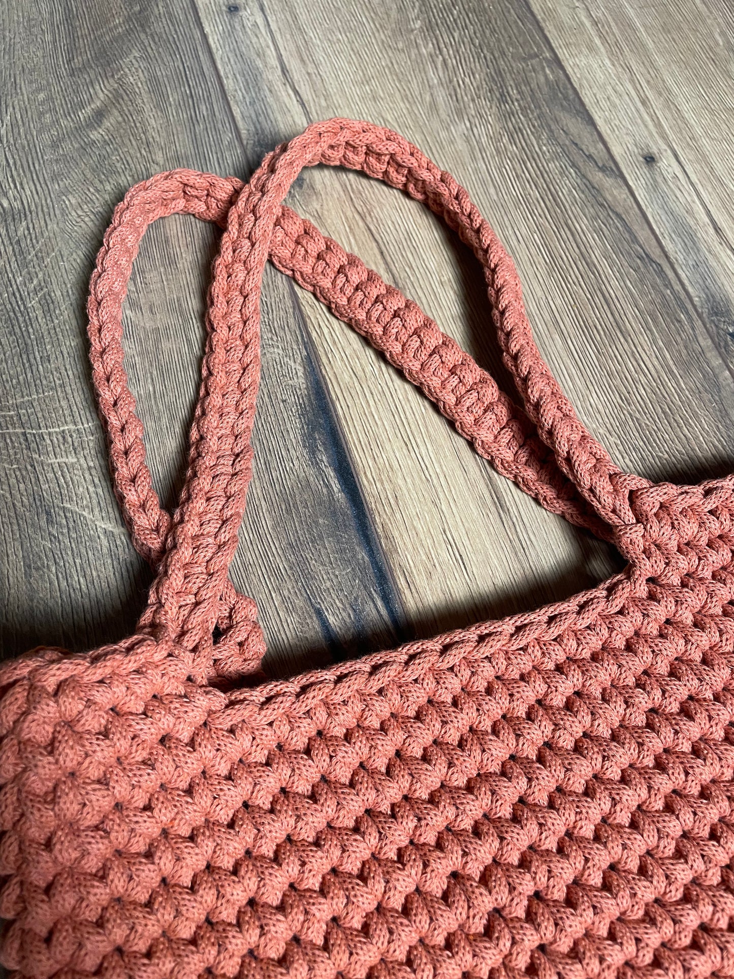 Nahaufnahme der FLORA Häkeltasche in terracotta-orangener Farbe. Das Bild zeigt deutlich die einzelnen Häkelmaschen und die Struktur des recycelten Baumwollgarns. Die handwerkliche Qualität und das gleichmäßige Maschenbild der Handarbeit sind gut erkennbar.