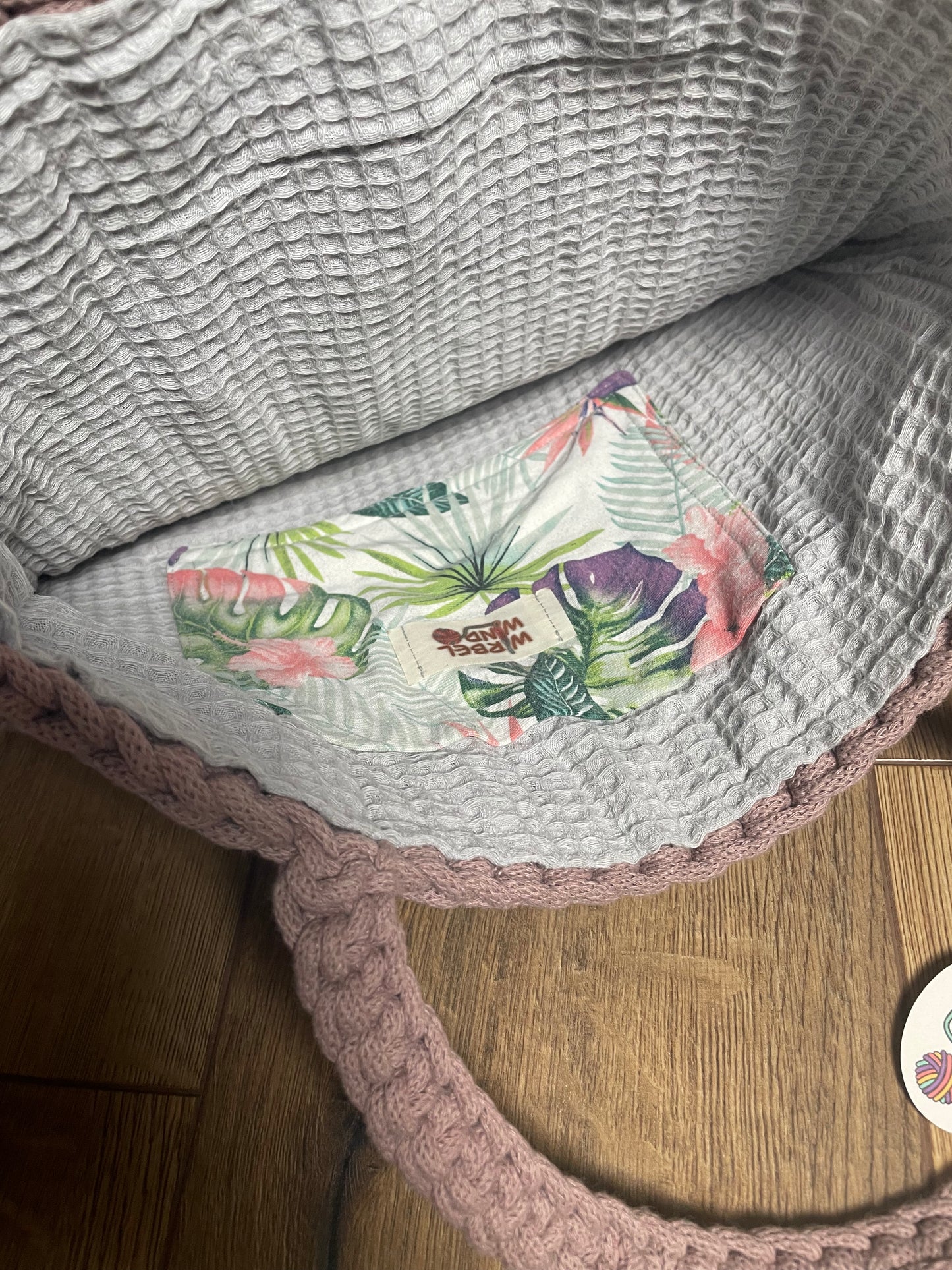 FLORA Häkeltasche in Mauve Rosa, Innenansicht: geöffnete Tasche zeigt das hellgraue Innenfutter aus Baumwoll-Waffelpiquet-Stoff mit kleiner aufgenähter Innentasche mit floralem Muster in grün, lila, blau-grau und rosa.