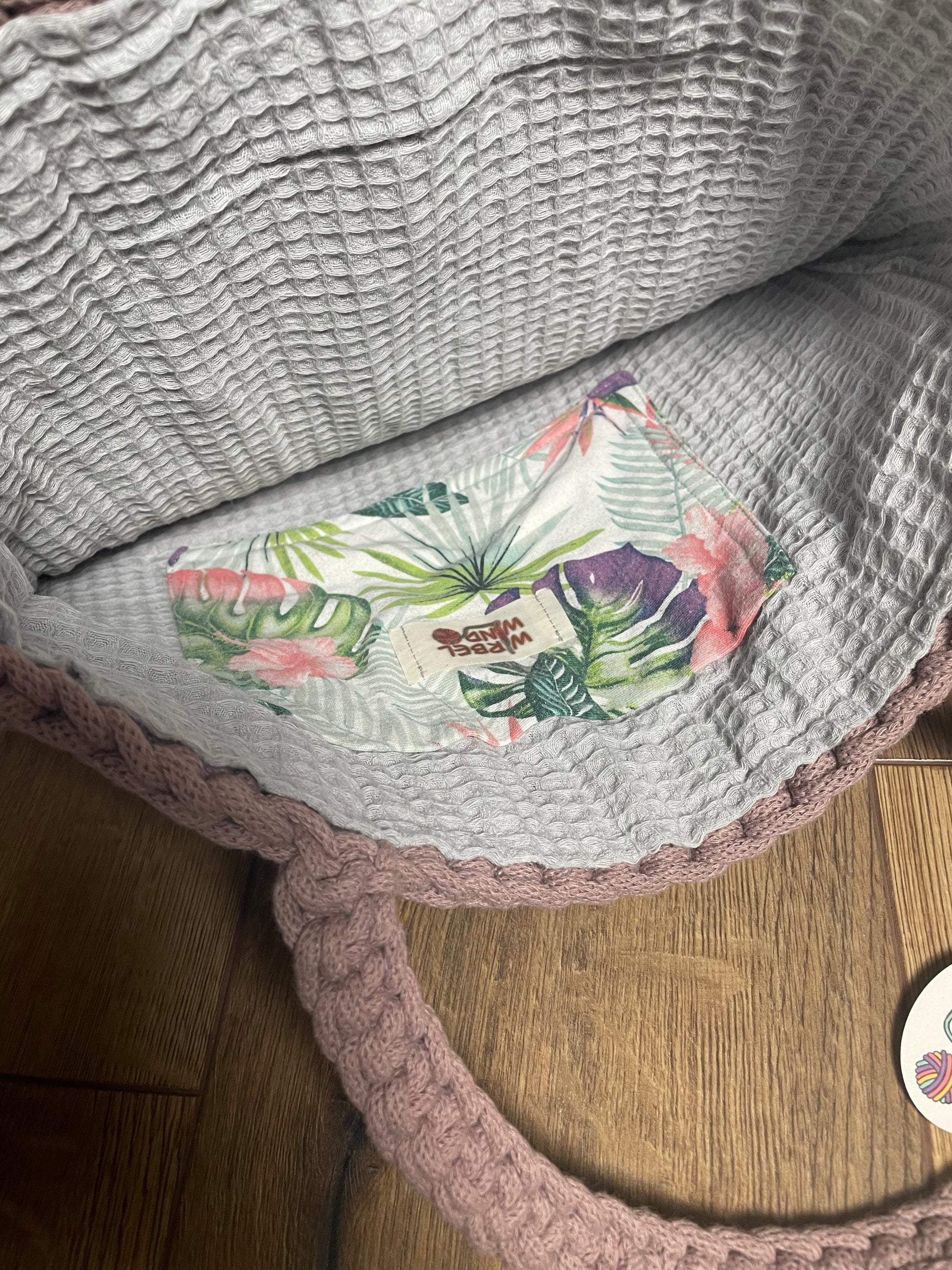 FLORA Häkeltasche in Mauve Rosa, Innenansicht: geöffnete Tasche zeigt das hellgraue Innenfutter aus Baumwoll-Waffelpiquet-Stoff mit kleiner aufgenähter Innentasche mit floralem Muster in grün, lila, blau-grau und rosa.