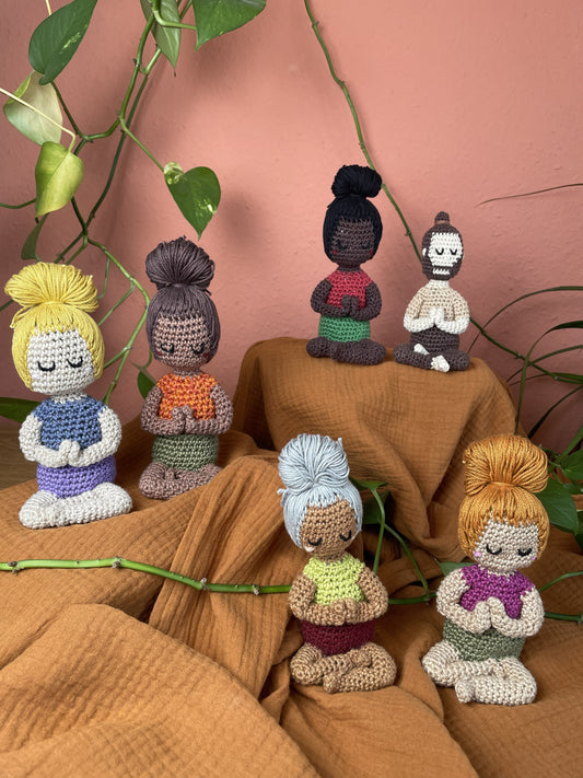 6 Yoga-Figuren sitzen auf unterschiedlichen Höhen, sind umgeben von einer Efeututenranke.