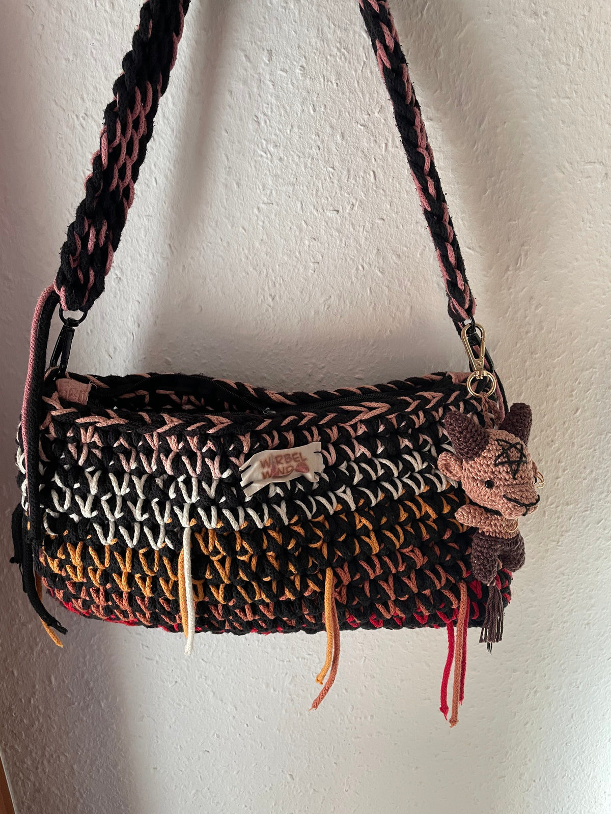 Braunes Lamm an einer Handtasche befestigt.