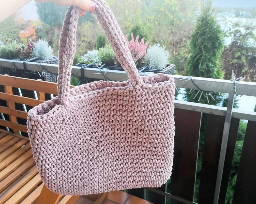FLORA Häkeltasche in Mauve Rosa, Vorderansicht: trapezförmige Schultertasche mit breiter Öffnung oben (ca. 39 cm) und schmalerer Basis unten (ca. 30 cm), Höhe 34 cm. Handgehäkelt aus recyceltem Baumwollgarn mit sichtbarem, strukturiertem Maschenmuster. Zwei Schulterriemen aus demselben Material.