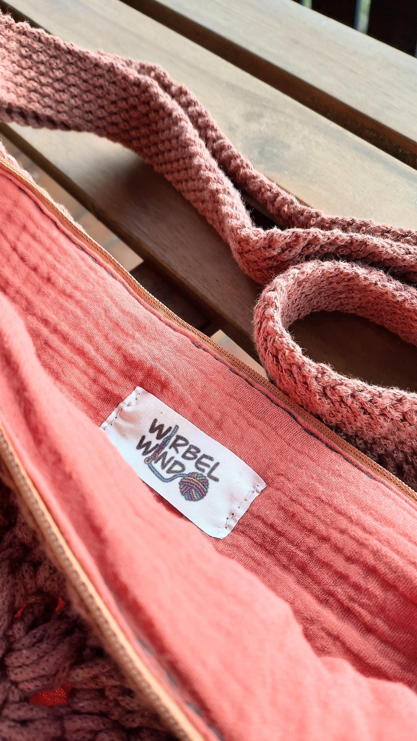 Reißverschluss der Tasche wurde geöffnet, Musselinstoff im Inneren, in einer ähnlichen Farbe wie das Garn, ist zu sehen, sowie das WIRBELWIND Logo.