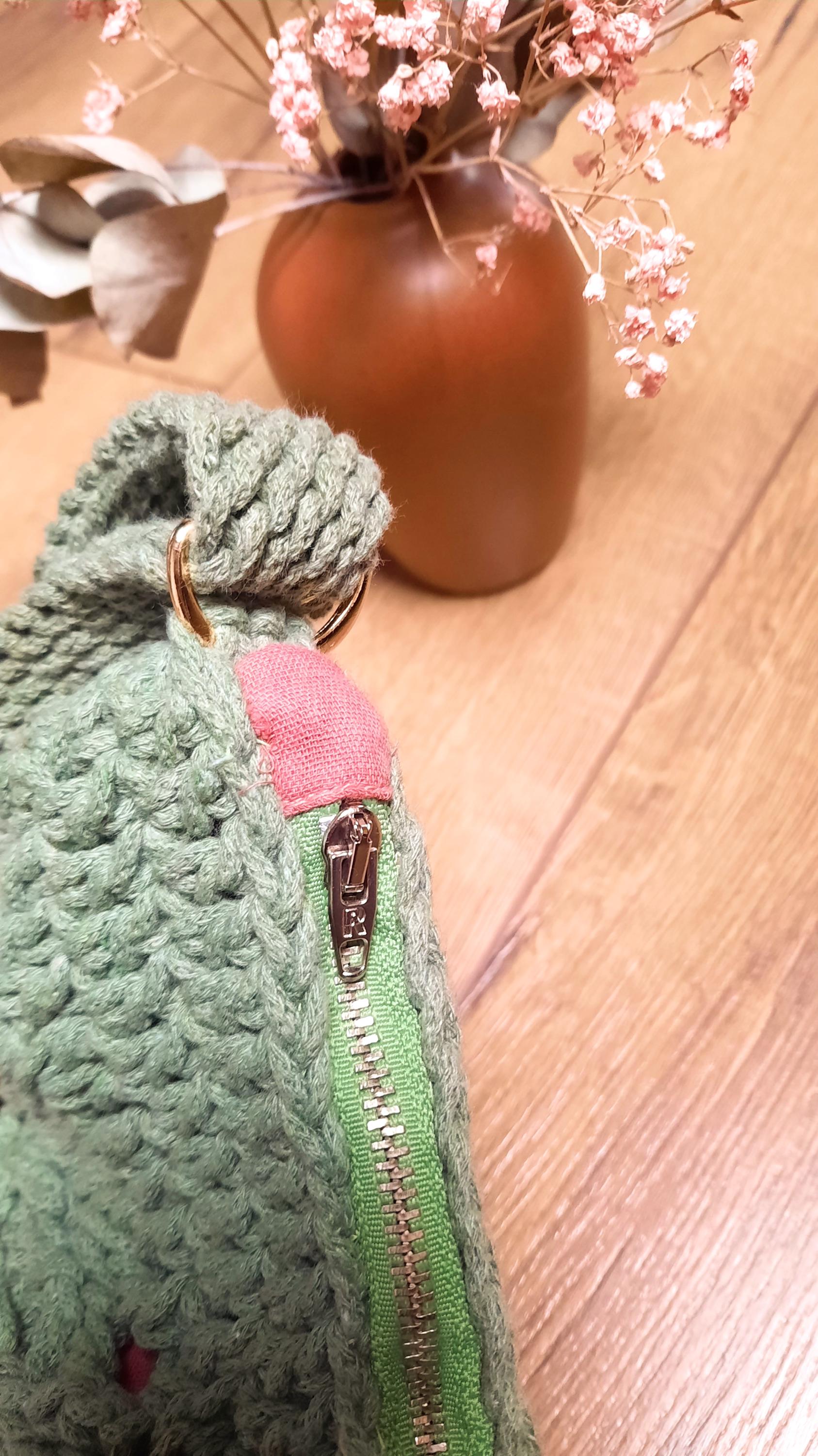 Nahaufnahme des grünen Reißverschlusses, der in pinken Stoff eingelassen ist. 